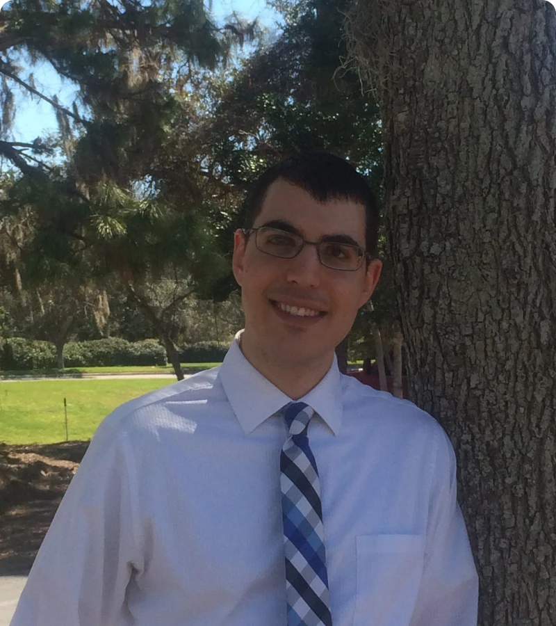 Person wearing glasses and tie outdoors