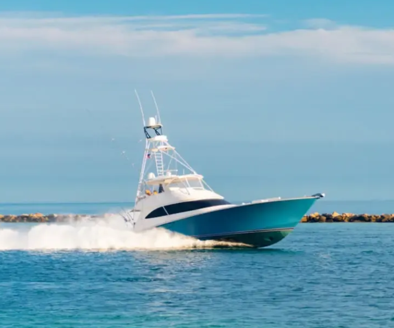 A sleek motorboat speeding across clear blue water.